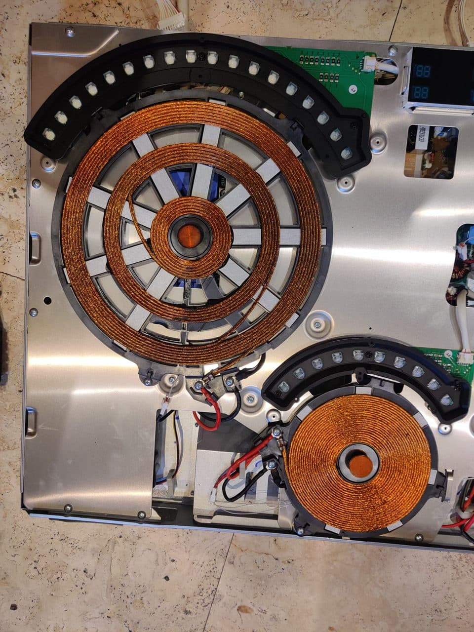Induction coils with the cooktop glass removed: Samsung induction range, model NE58K9560WS (oven & stove repair in Wilton Manors, FL, July 2026)